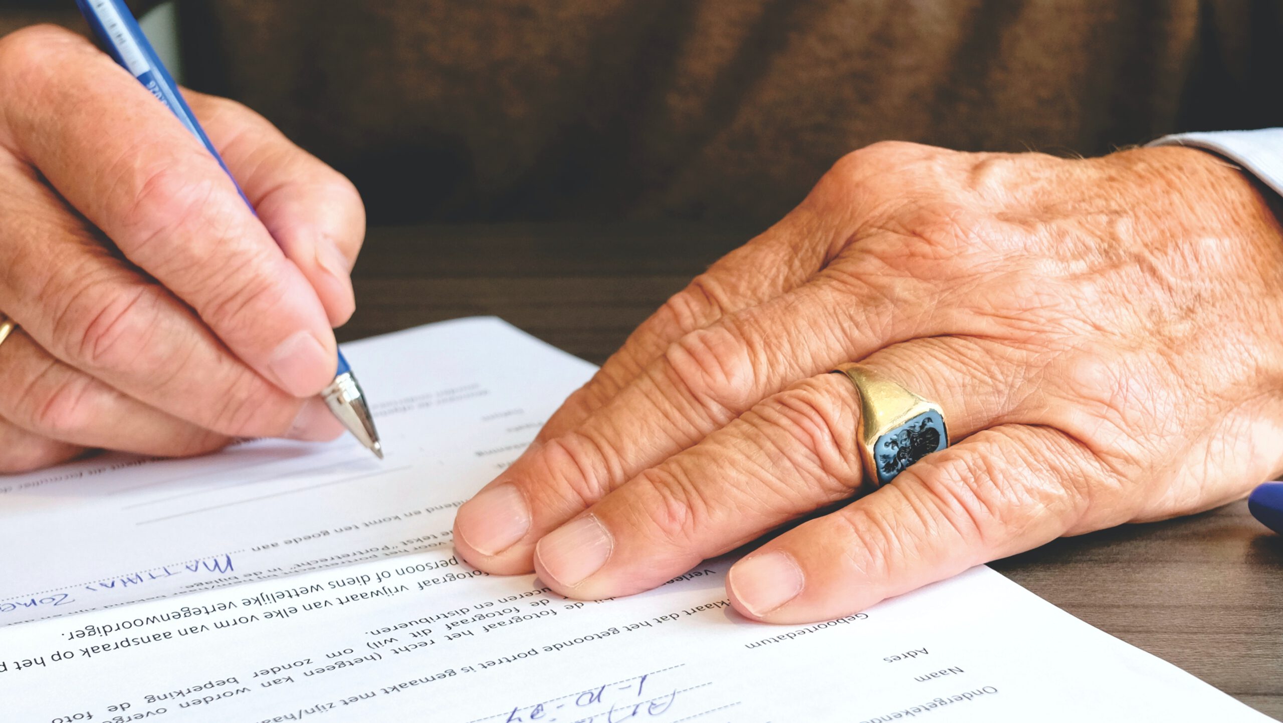 Dłoń mężczyzny podpisująca dokument związany z oceną zdolności kredytowej przedsiębiorstwa